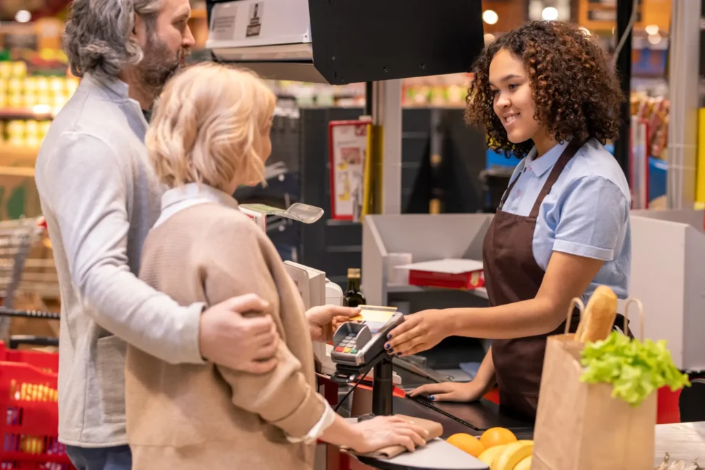happy-young-mixed-race-female-cashier-in-apron-loo-2023-11-27-05-03-29-utc happy-young-mixed-race-female-cashier-in-apron-loo-2023-11-27-05-03-29-utc